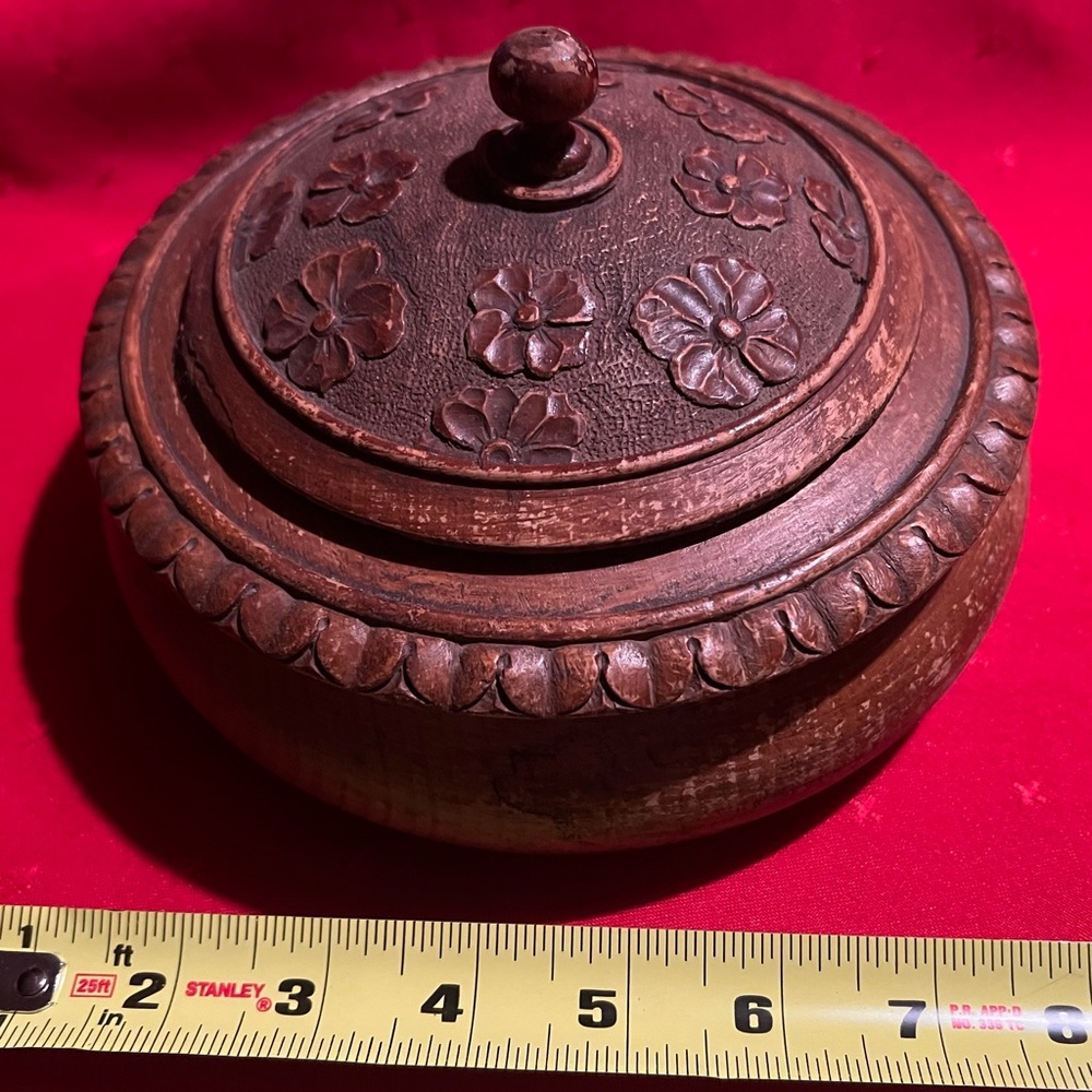 A vintage, hand-carved wooden box with a lid, possibly of Indian origin